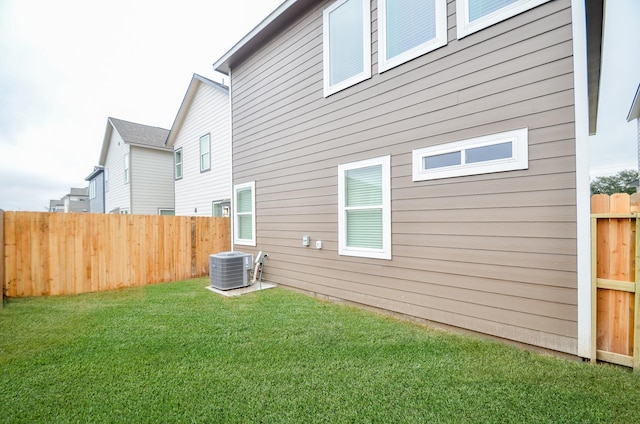 back of property featuring a yard and central AC