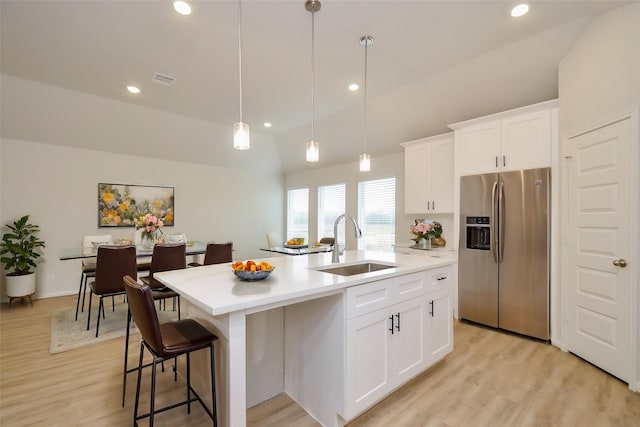 kitchen featuring white cabinetry, stainless steel refrigerator with ice dispenser, sink, and an island with sink