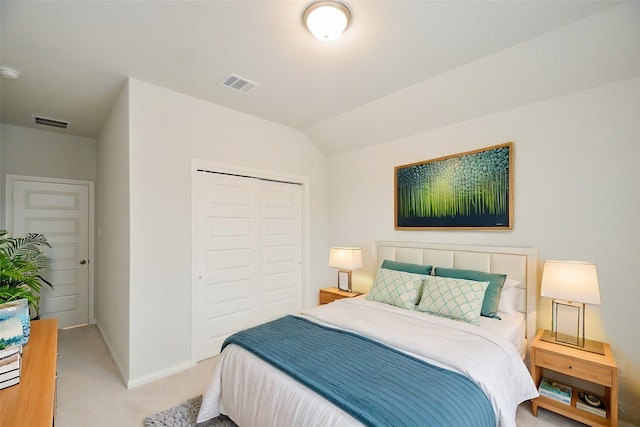 carpeted bedroom with lofted ceiling and a closet