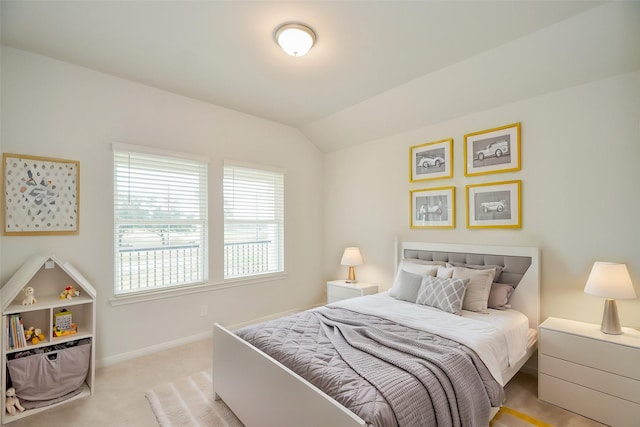 bedroom featuring lofted ceiling and light carpet