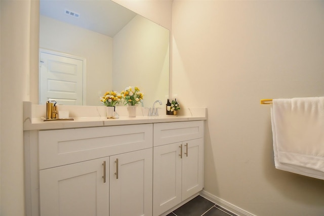 14983 Eagle Feather Dr, Houston, TX 77090 - bathroom featuring tile patterned floors, double vanity, visible vents, a sink, and baseboards