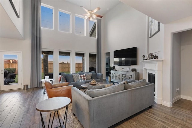 living room with hardwood / wood-style flooring, high vaulted ceiling, plenty of natural light, and ceiling fan