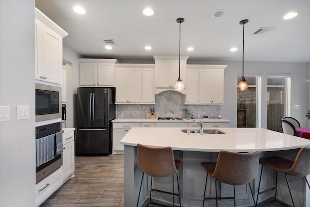 kitchen with white cabinetry, sink, pendant lighting, and appliances with stainless steel finishes