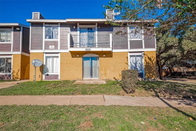 exterior space with a front yard and a balcony