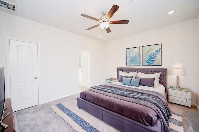 carpeted bedroom with ensuite bath and ceiling fan