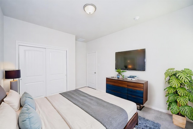 bedroom featuring light colored carpet and a closet