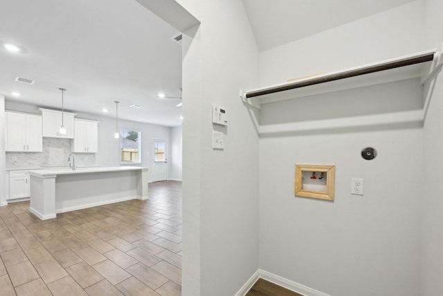 clothes washing area with hookup for a washing machine and sink