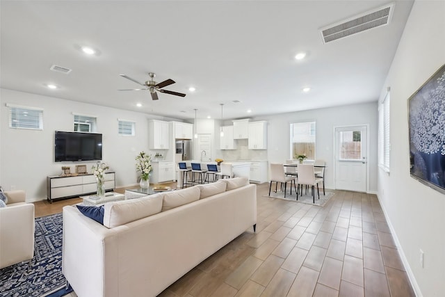 living room featuring ceiling fan and light hardwood / wood-style floors