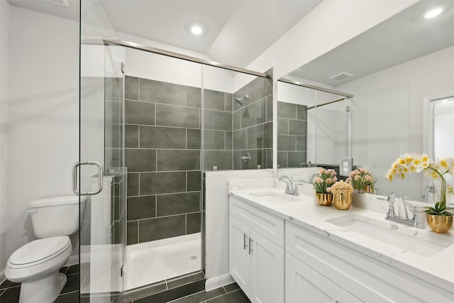 bathroom with walk in shower, vanity, and toilet