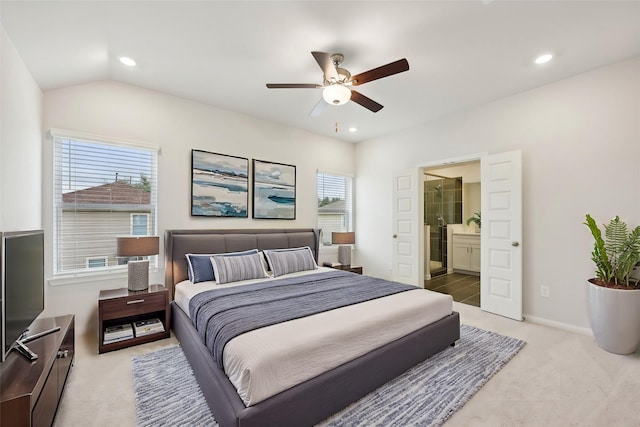 carpeted bedroom featuring vaulted ceiling, ensuite bathroom, and ceiling fan