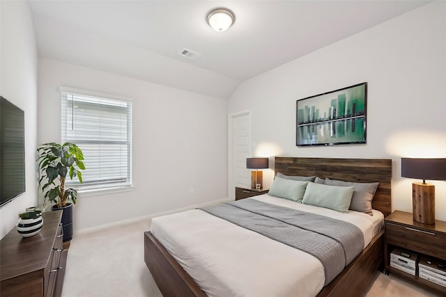 bedroom featuring light colored carpet and lofted ceiling