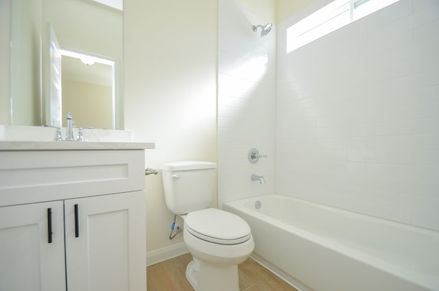 full bathroom featuring toilet, wood finished floors, tub / shower combination, baseboards, and vanity