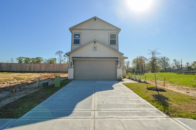 traditional-style home featuring concrete driveway, a front yard, and fence