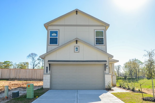 view of front facade featuring a garage, driveway, and fence