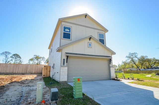 view of front facade featuring concrete driveway and fence
