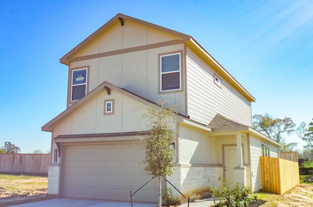 view of front of home with concrete driveway, fence, stone siding, and roof with shingles