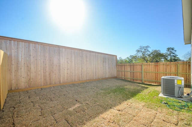 view of yard featuring central AC unit and a fenced backyard