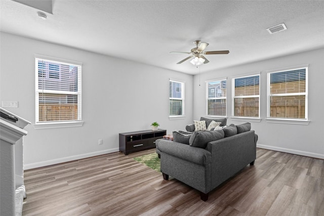 living room featuring a textured ceiling, hardwood / wood-style flooring, and ceiling fan