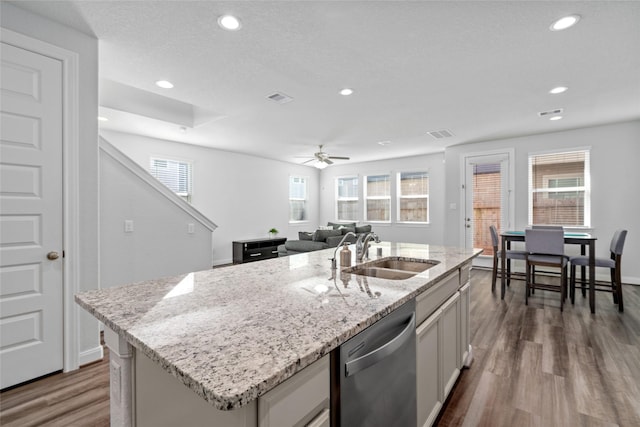 kitchen with dishwasher, sink, a wealth of natural light, and an island with sink