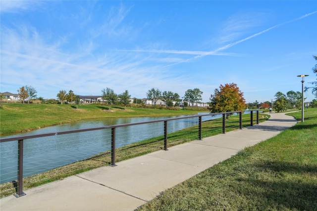 surrounding community with a water view and a yard