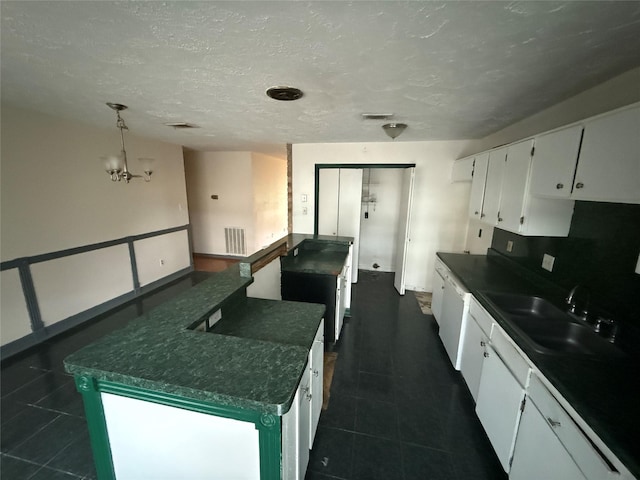 kitchen with a kitchen island, sink, dishwasher, a chandelier, and white cabinetry