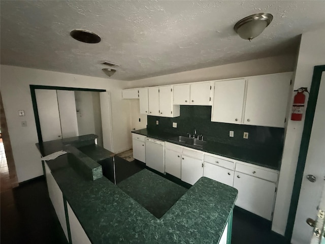 kitchen featuring backsplash, sink, white cabinets, and white dishwasher