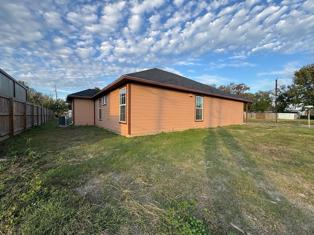 view of side of property with a yard and central AC unit