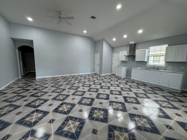 kitchen featuring white cabinetry, sink, wall chimney exhaust hood, ceiling fan, and vaulted ceiling