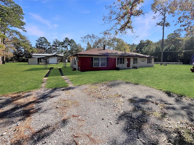 view of front of property with a garage, an outdoor structure, and a front yard