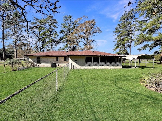 rear view of house featuring a carport and a lawn