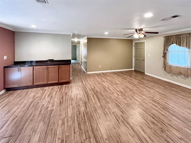 unfurnished living room featuring light hardwood / wood-style floors, ceiling fan, and ornamental molding