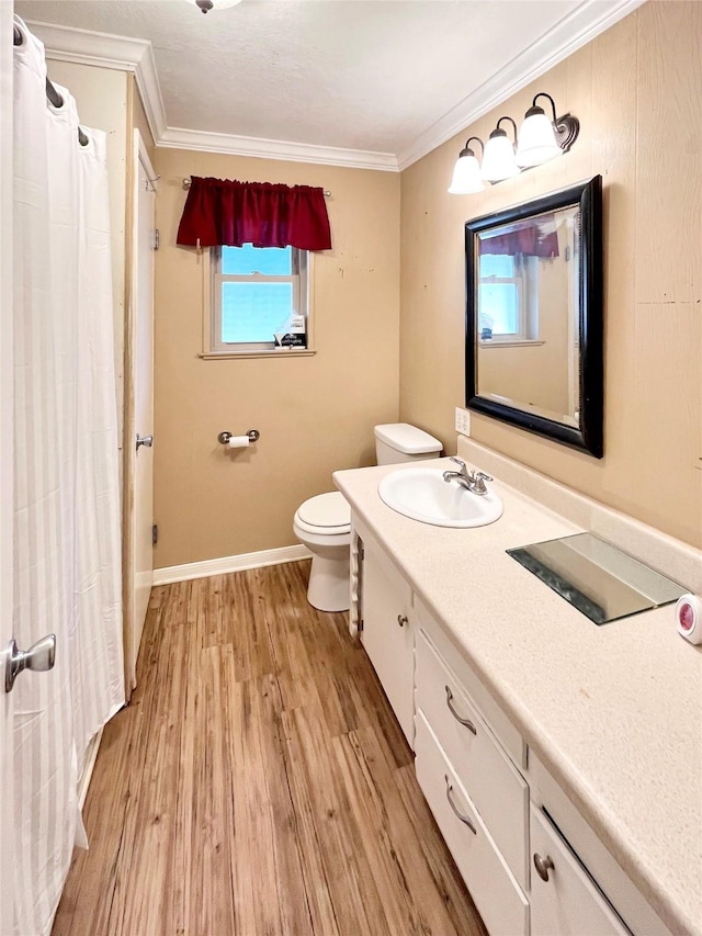 bathroom featuring toilet, vanity, wood-type flooring, and ornamental molding