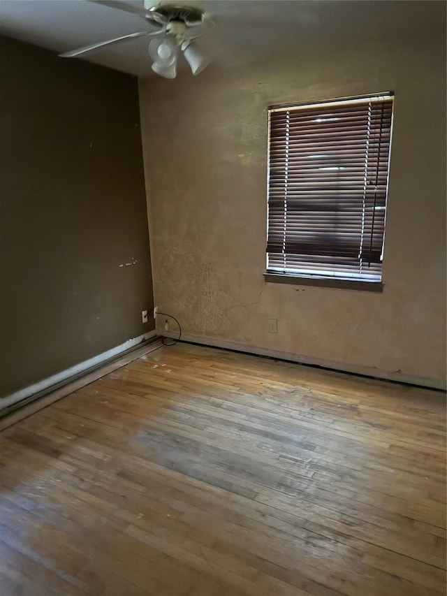 empty room with ceiling fan and light hardwood / wood-style flooring