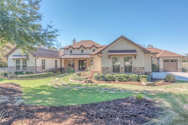 view of front of home with a garage and a front lawn