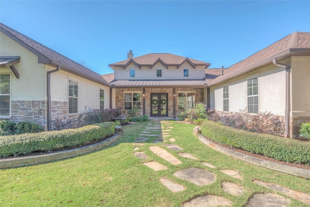 exterior space with french doors and a lawn