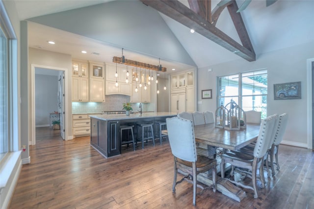 dining area with dark hardwood / wood-style floors, beam ceiling, and high vaulted ceiling