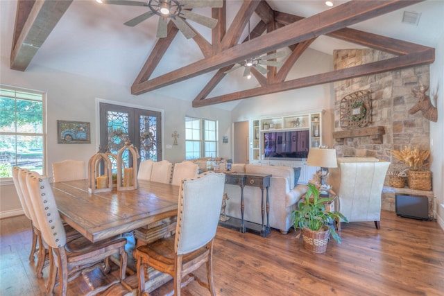 dining area with beamed ceiling, wood-type flooring, high vaulted ceiling, and french doors