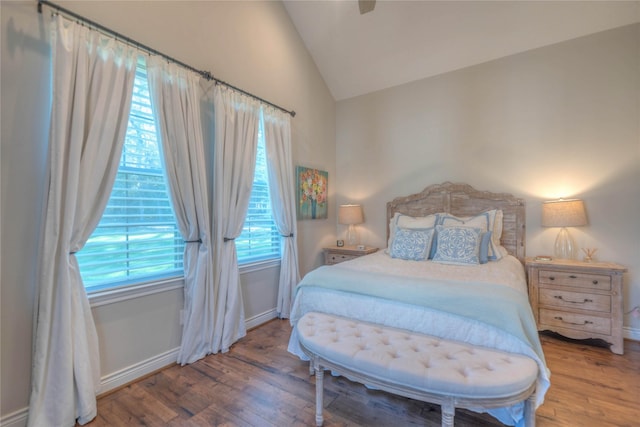 bedroom featuring hardwood / wood-style floors, vaulted ceiling, and ceiling fan