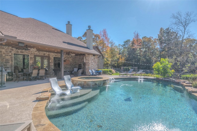 view of pool with an in ground hot tub, a patio, and pool water feature