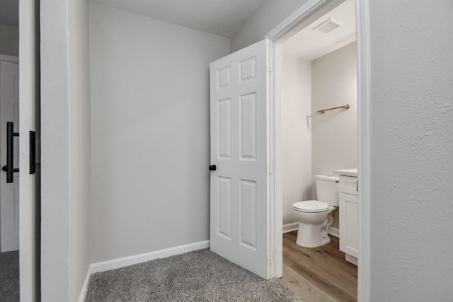 bathroom with wood-type flooring, vanity, and toilet