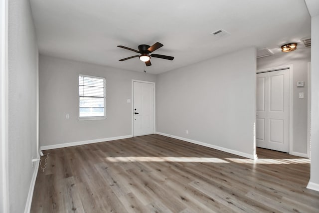 empty room with ceiling fan and light hardwood / wood-style floors