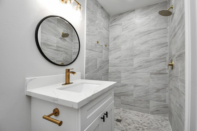 bathroom with vanity and tiled shower