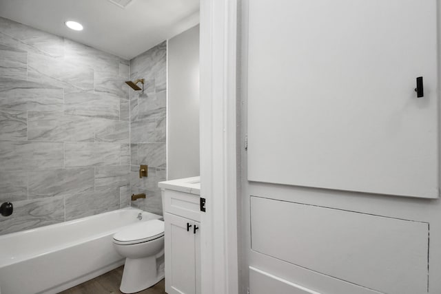 full bathroom with hardwood / wood-style flooring, tiled shower / bath combo, toilet, and vanity