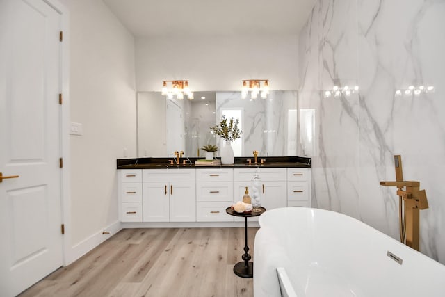 bathroom featuring a washtub, wood-type flooring, and vanity