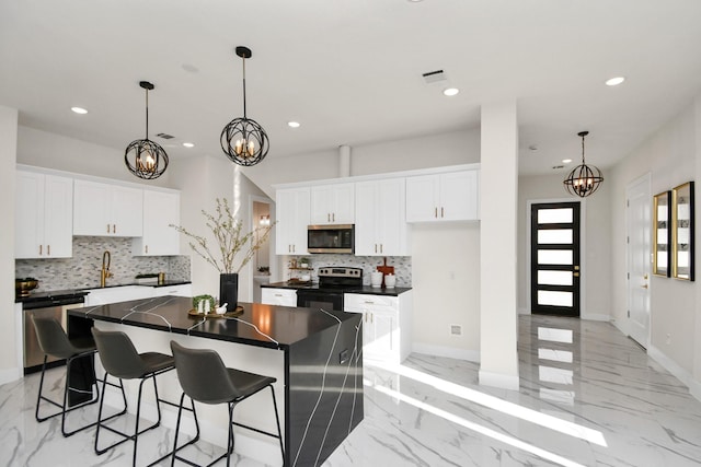 kitchen with backsplash, a center island, white cabinetry, and stainless steel appliances