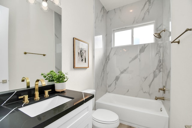 full bathroom featuring vanity, tiled shower / bath combo, and toilet