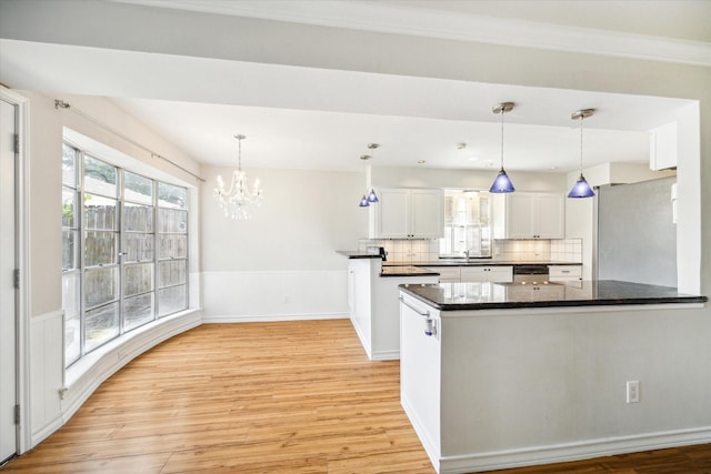 kitchen with white cabinets, pendant lighting, backsplash, and light hardwood / wood-style flooring