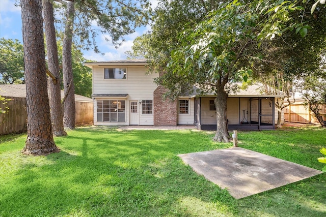 back of house with a lawn, a sunroom, and a patio area