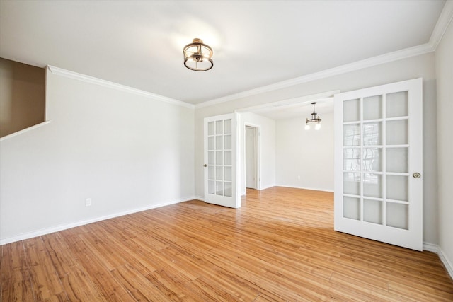 unfurnished room with an inviting chandelier, light hardwood / wood-style flooring, and french doors