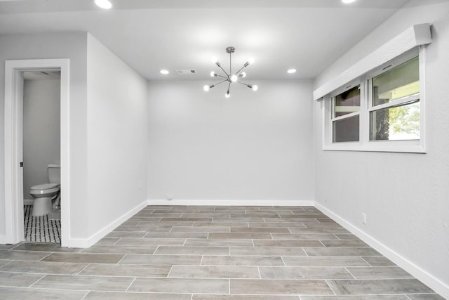 unfurnished room with a chandelier